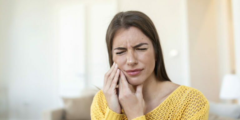 Tooth Pain And Dentistry. Beautiful Young Woman Suffering From Terrible Strong Teeth Pain, Touching Cheek With Hand. Female Feeling Painful Toothache. Dental Care And Health Concept. High Resolution